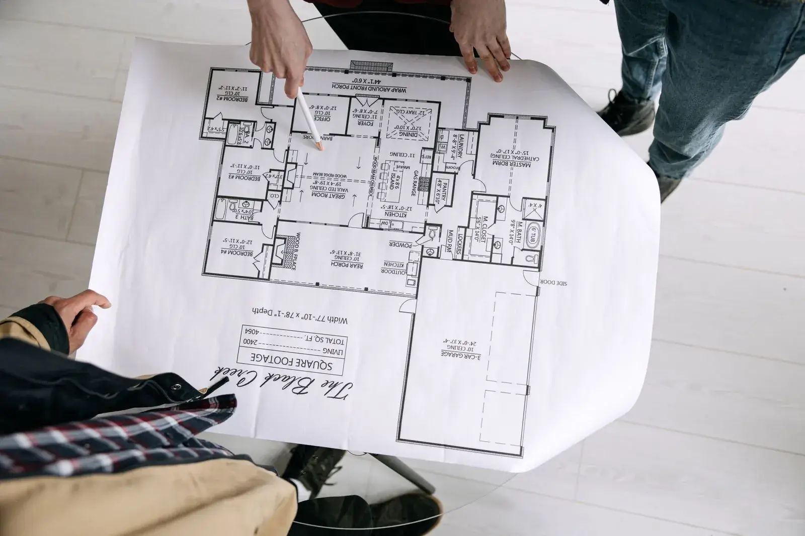 People reviewing printed house plans on a table