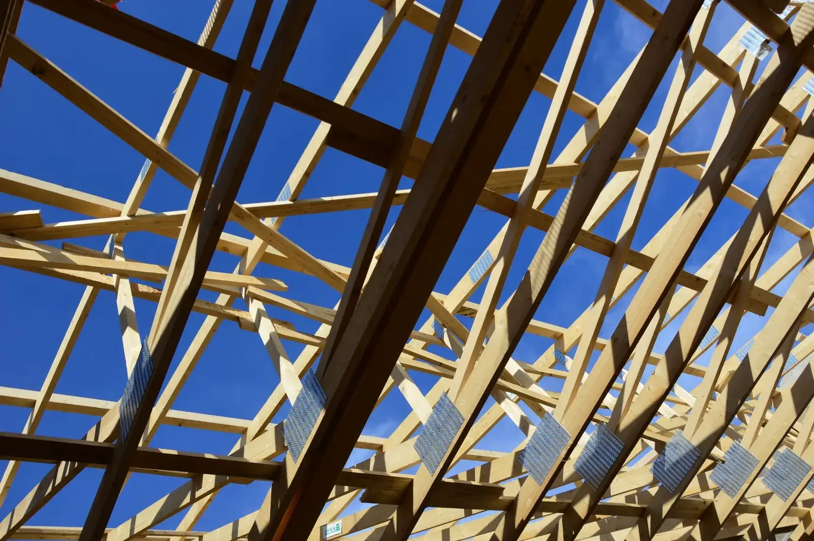 Roof trusses of a house under construction against a blue sky